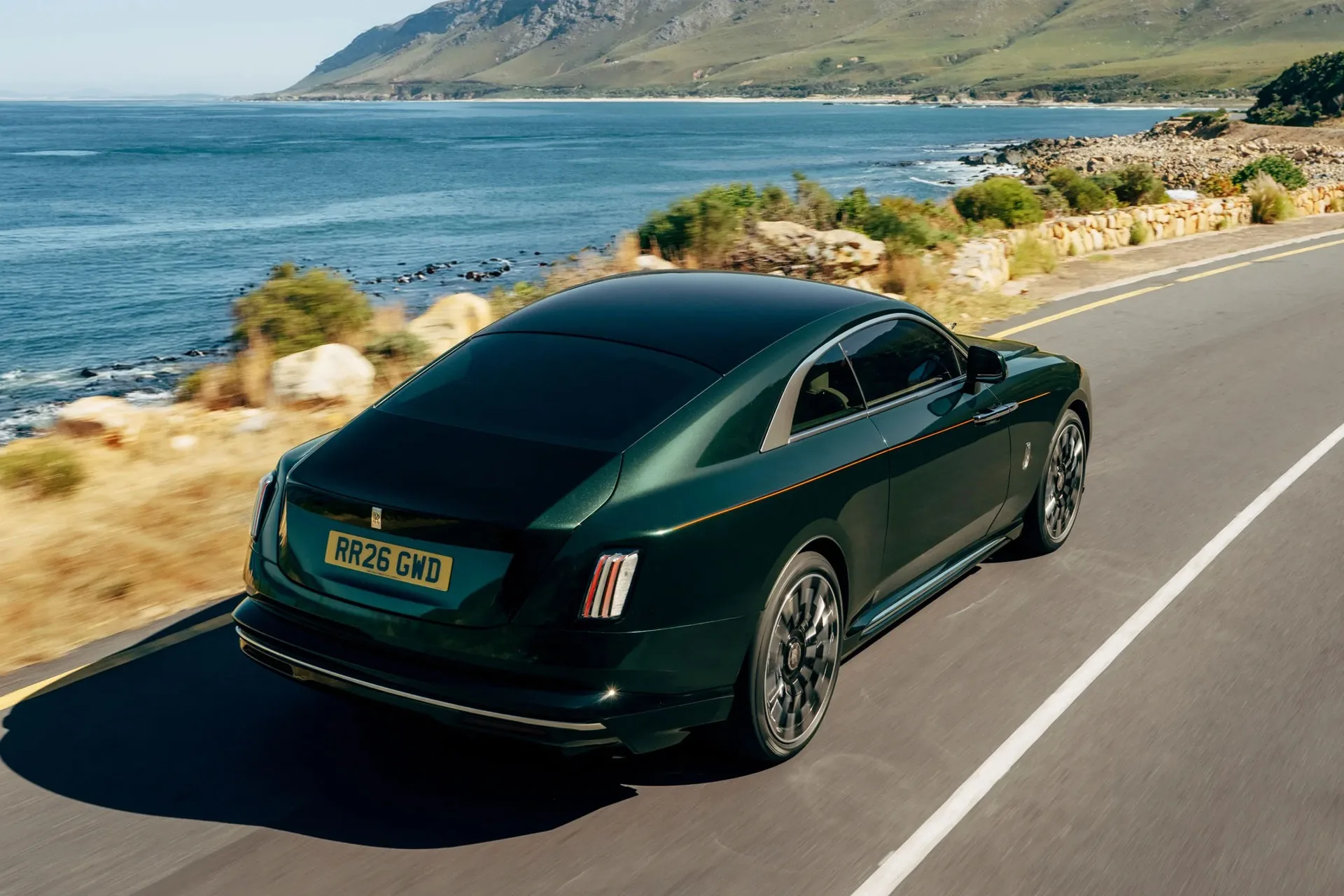 Rolls-Royce Spectre Series II v zeleni barvi ob morski obali, pogled od zadaj